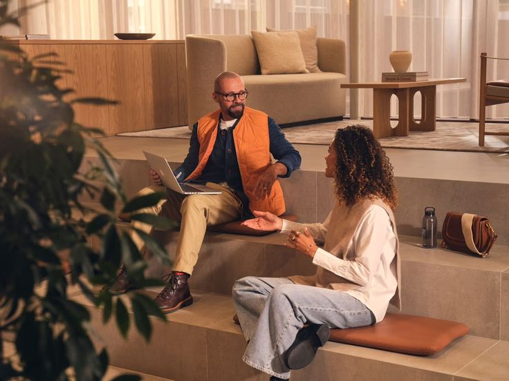 Двое коллег обсуждают задачи в лаунж-зоне